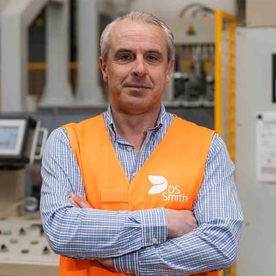 Piet Algoet, General Manager DS Smith Harelbeke, in een oranje vest voor een machine