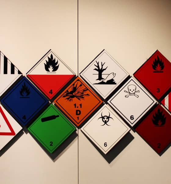 Unterschiedliche Gefahrgutetiketten an einer Wand.