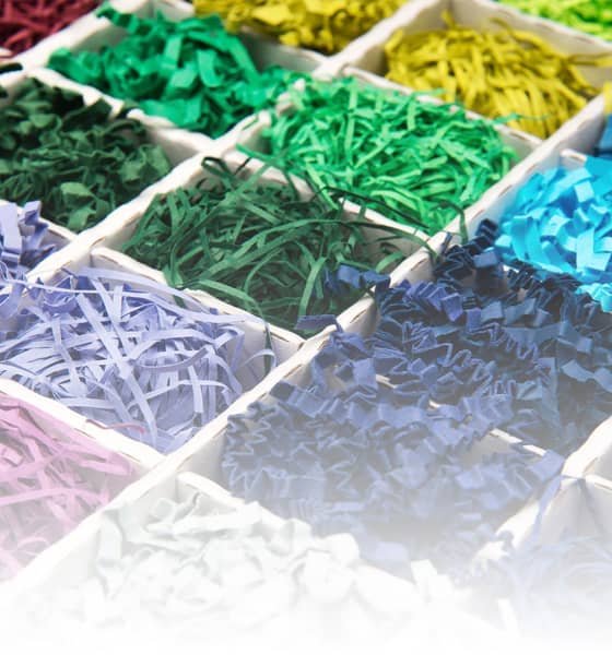 Een collectie levendig gekleurd SizzlePak-papier, gepresenteerd in een doos, met een scala aan kleuren voor decoratief gebruik.