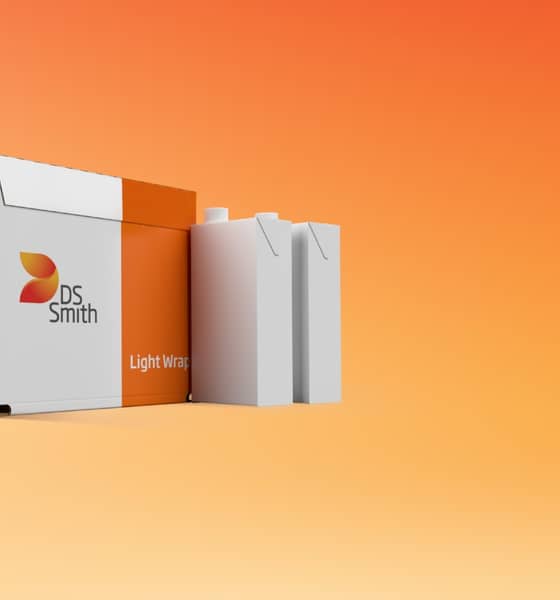 Eine Box der Umverpackung "Light Wrap" mit DS Smith Logo steht vor orangenem Hintergrund neben zwei leeren Tetrapacks