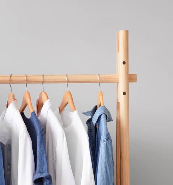 Mehrere Hemden in weiß und in Jeansoptik auf einer Stange aufgehängt.