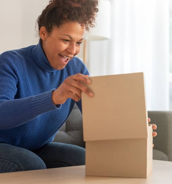 nainen katsoo aaltopahvista laatikkoa