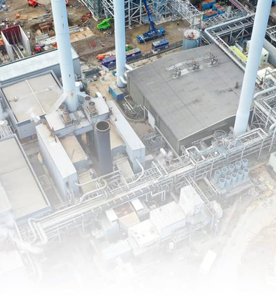 Luchtfoto van een industriële productielocatie met pijpleidingen, opslagtanks, gebouwen.