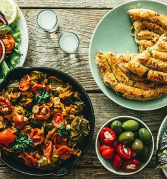 Gedeckter Tisch mit frisch zubereiteten Speisen.