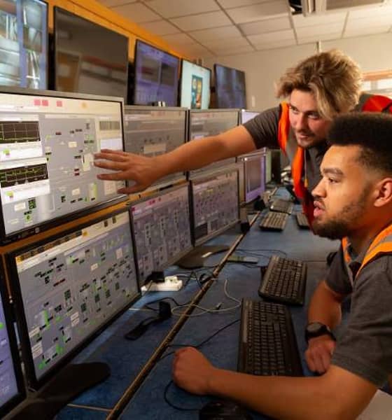 two people observing data on a computer screen