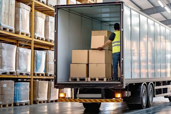 lastbil i lagerhal der læsser papkasser