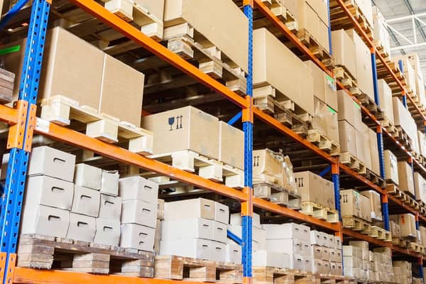 teollisuusvaraston hylly jossa pahvisia pakkauksia