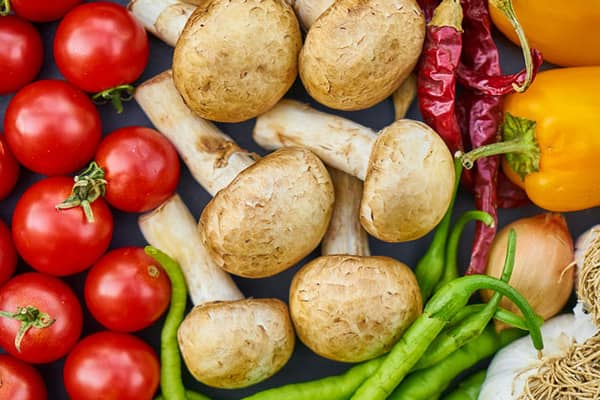 värikkäitä tomaatteja, sieniä, paprikoita ja muita vihanneksia