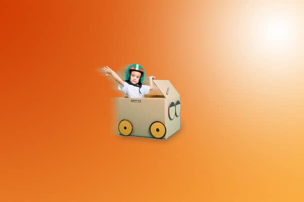 poika pahvilaatikossa leikkimässä