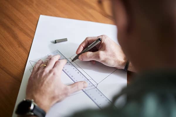 käsi ja suunnittelupaperi, johon käis piirtää