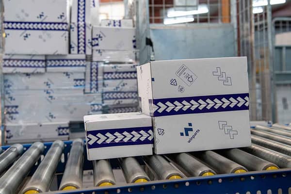 Witte golfkartonnen dozen met blauw logo op rollerbaan