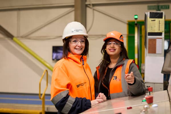 Two female packaging plant workers wearing International Paper and DS Smith protective equipment.