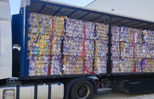 Lkw voll gefüllt mit Altpapierballen in der Seitenansicht.