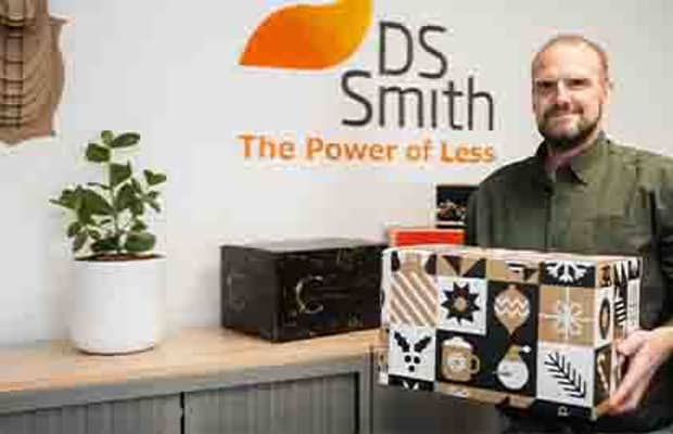 Medewerker DS Smith toont trots een geproduceerde kerstpakketdoos