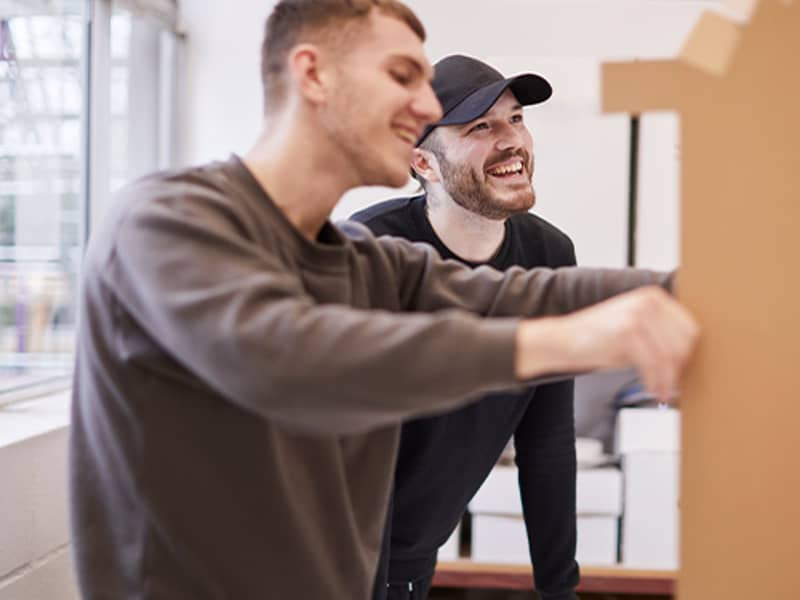 Two male graduates working on a cardboard display