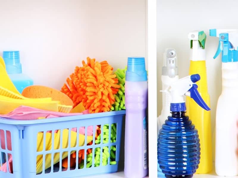 Wäschekorb mit Putzlappen und Putzmittel.