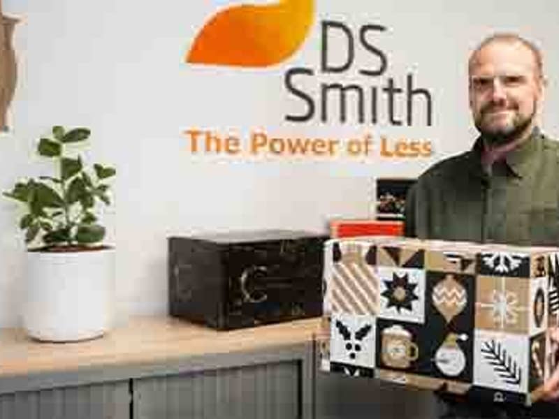 Medewerker DS Smith toont trots een geproduceerde kerstpakketdoos