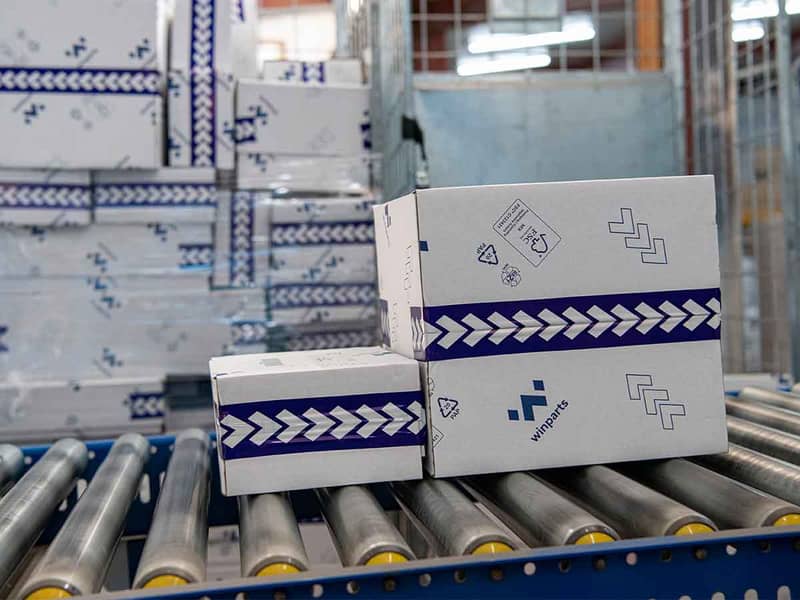 Witte golfkartonnen dozen met blauw logo op rollerbaan