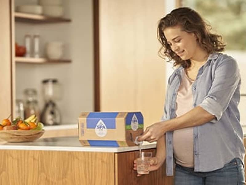 Vrouw tapt water uit bag-in-box in de keuken