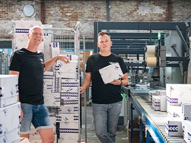 Twee collega's van winparts in e-commerce magazijn met verpakkingen 