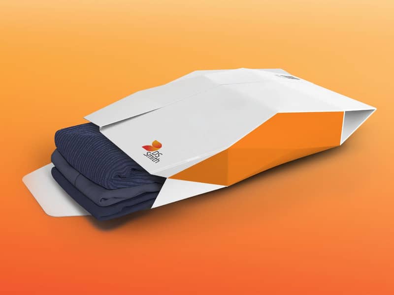 Kartonnen enveloppe gevuld met 3 t-shirts op een oranje achtergrond 