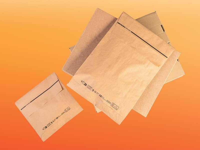 Papieren verzendzakken op een oranje achtergrond