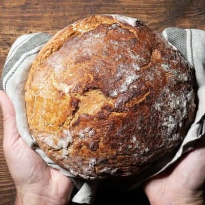 Zwei Hände halten ein Brot.