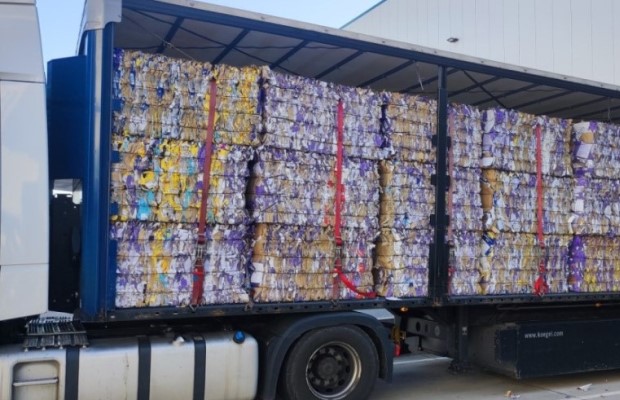 Lkw voll gefüllt mit Altpapierballen in der Seitenansicht.