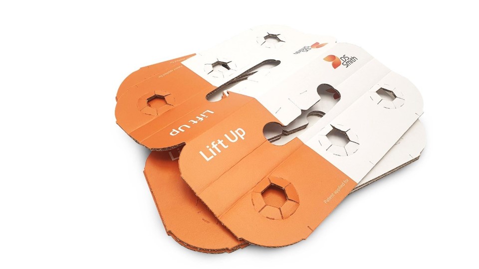 Mehrere weiß, orangenen Top Clips aus Wellpappe liegen flach übereinander. 