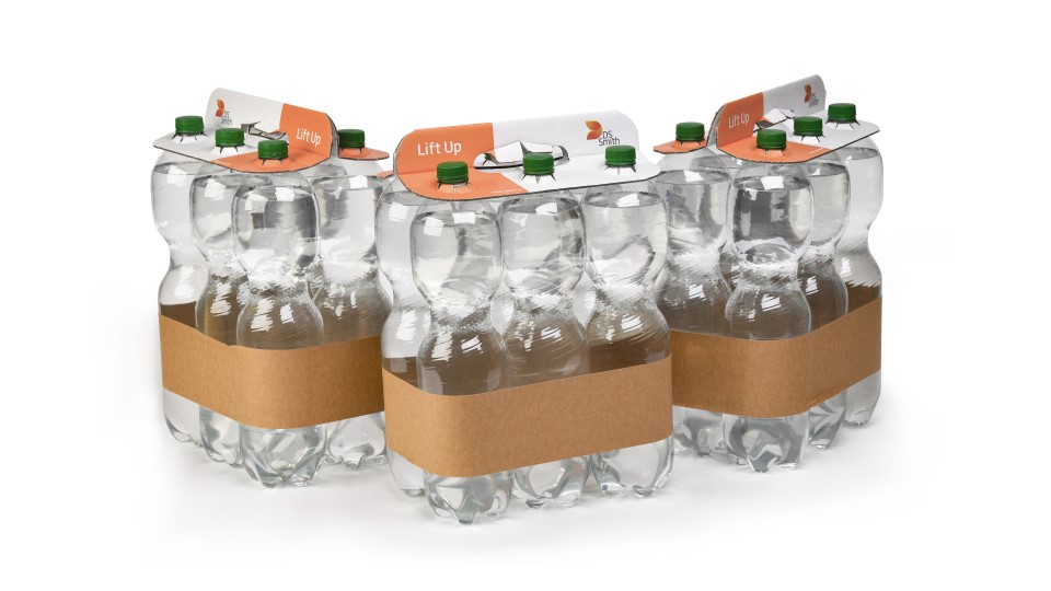 Drei Sixer Plastikflaschen gefüllt mit Wasser stehen nebeneinander. Alle Sixer werden durch eine braune Banderole und einen weiß, orangenen Top Clip zusammengehalten.