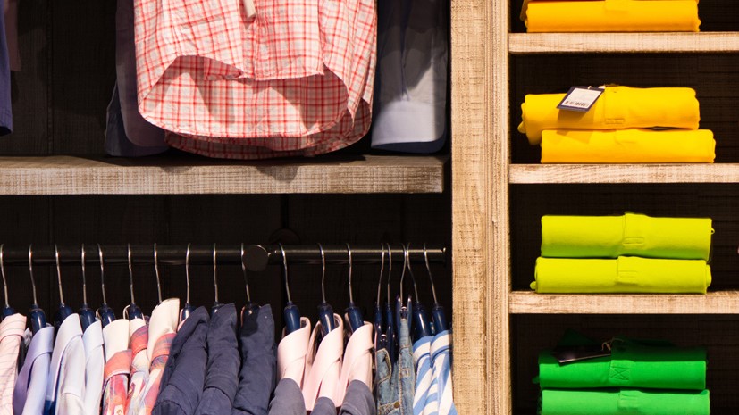 Nahaufnahme eines Kleiderschranks mit aufgehängten bunten Hemden.