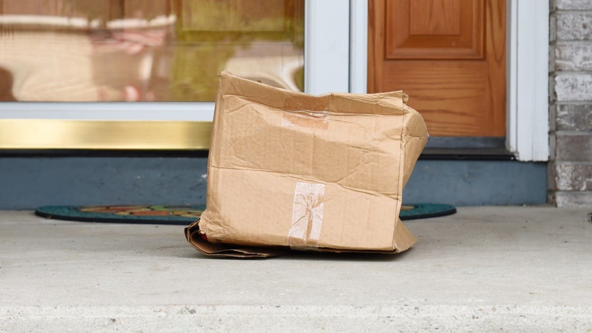 Beschädigte Box aus Wellpappe steht vor dem Haus