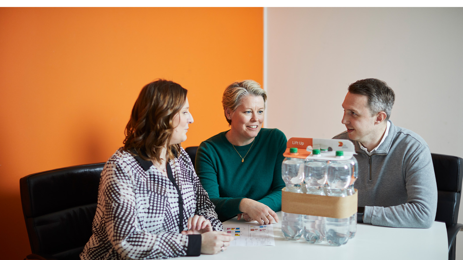 Ihmisiä juomapakkauksen ympärillä