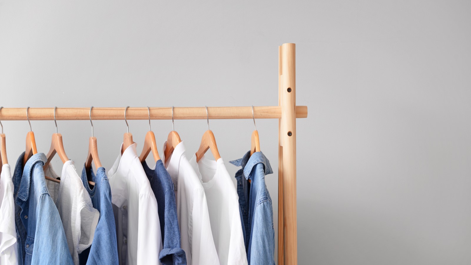 Mehrere Hemden in weiß und in Jeansoptik auf einer Stange aufgehängt.