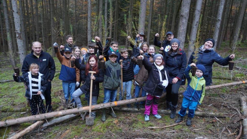 Baumpflanzaktion DS Smith 02_960x540.jpg Strahlende Kinder im Wald mit einem Baumsetzling in der Hand