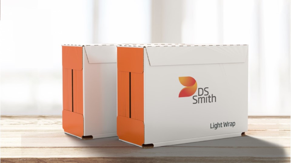zwei Umverpackungen in weiß-orangenem DS Smith Design stehen hintereinander auf einem Holzuntergrund