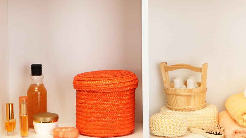 Nahaufnahme eines Regals im Badezimmer mit unterschiedlichen Toilettenartikeln.