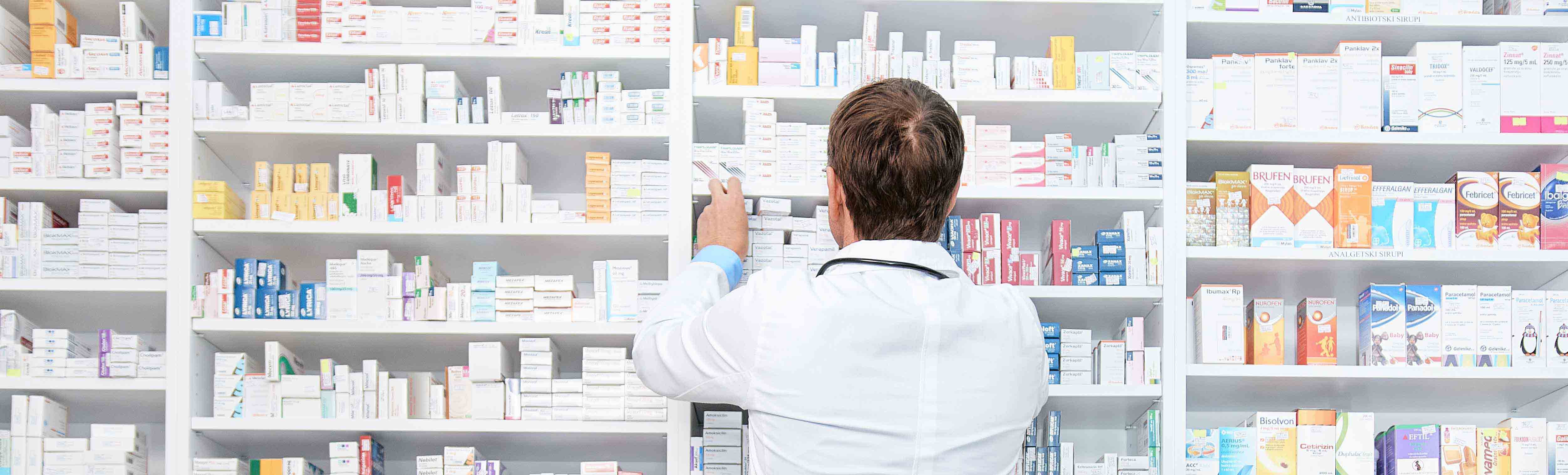 apoteker foran hylder med medicin