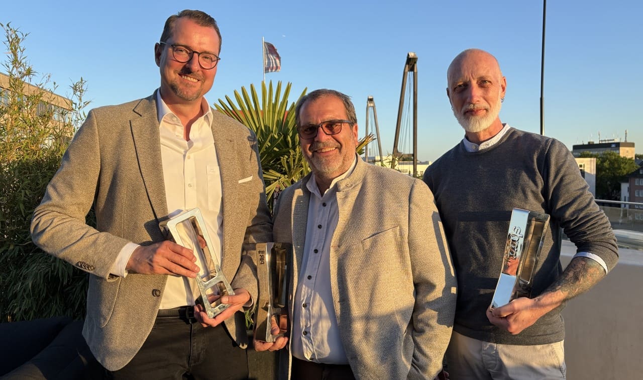 Drei Männer mit drei Silber-Trophäen in der Hand