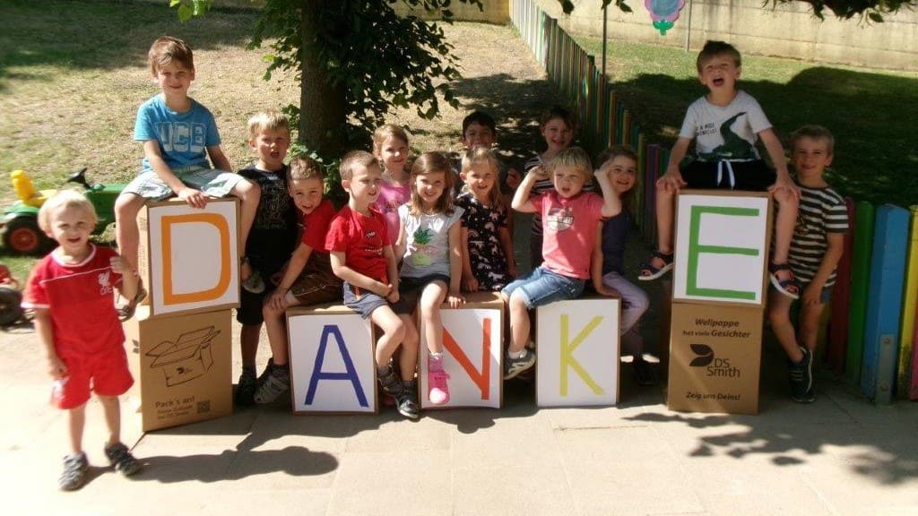 Kinder sitzen auf Hockern aus Wellpappe