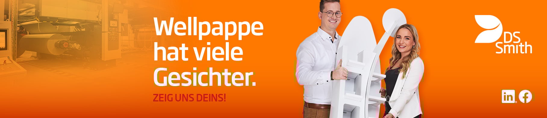 junger dunkelhaariger Mann mit weißem T-Shirt vor orangefarbenen Hintergrund lächelt in die Kamera und hält neben einem Kartonstapel einen kleinen Wellpappkarton in der Hand