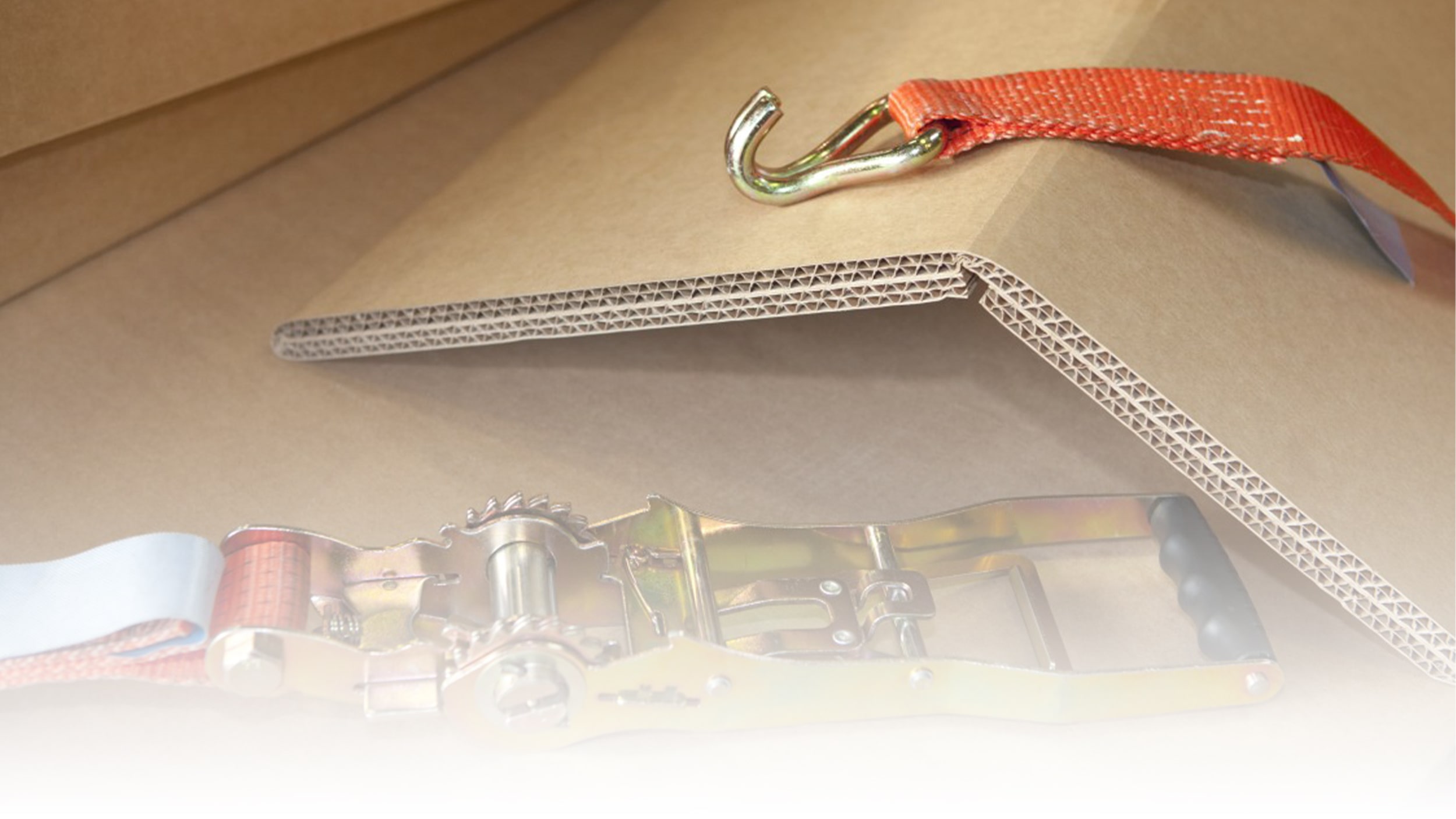 Mehrwellige Wellpappe auf welcher Spanngurte liegen.