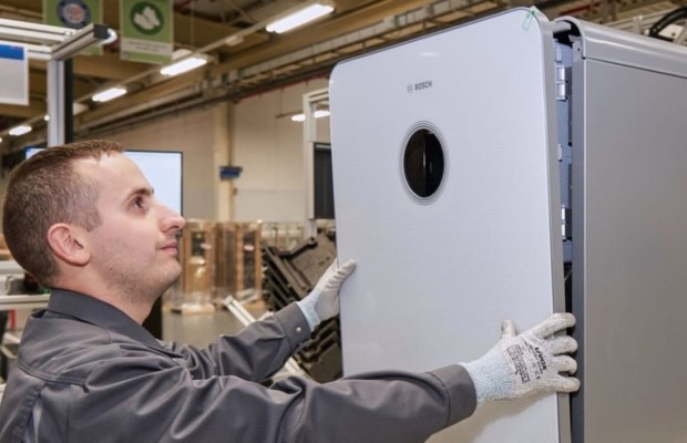 Mitarbeiter in der Produktion arbeitet daran eine weißer Gastherme von Bosch zusammenzusetzen