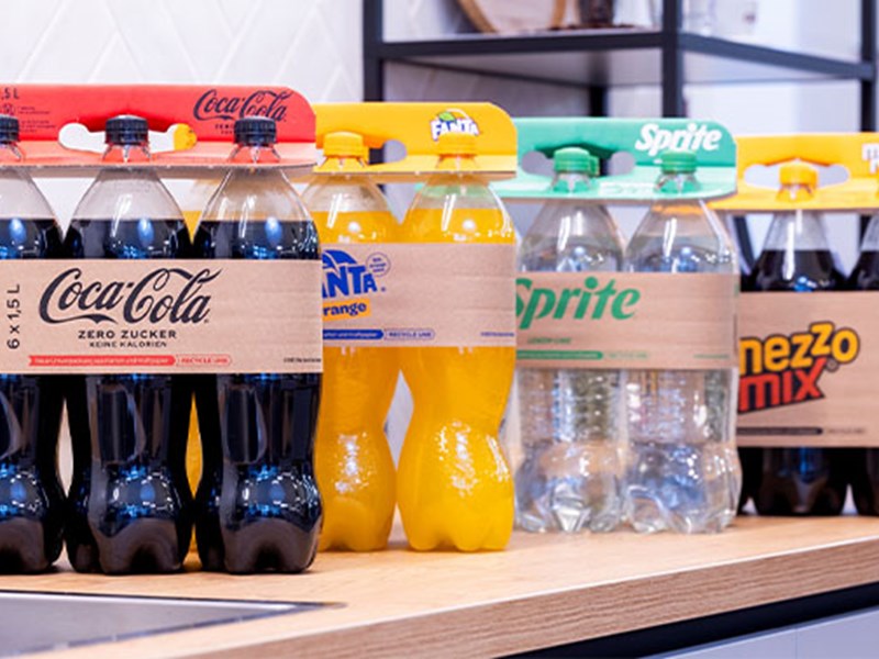 Flessen frisdrank, Coca-Cola, Fanta, Sprite, met een handvat van golfkarton