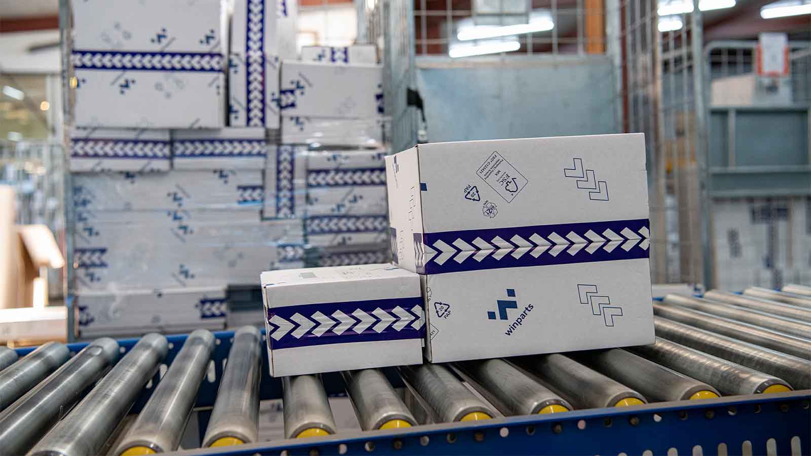 Witte golfkartonnen dozen met blauw logo op rollerbaan