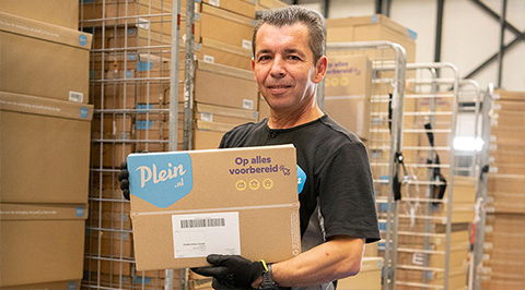 Medewerker van Plein in magazijn met bruine e-commerce verpakking 