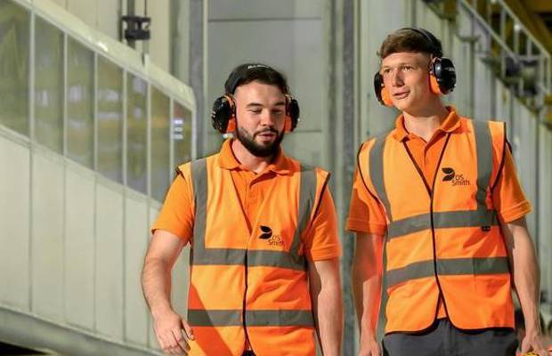 Zwei Lehrlinge gehen durch die Produktionshalle