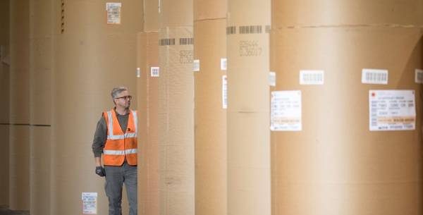 A person standing amongst giant paper reels